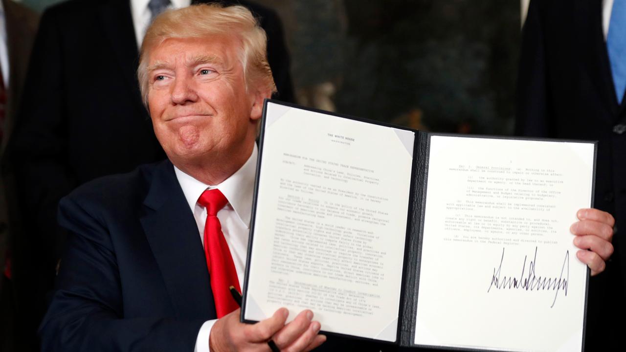 President Donald Trump signs executive action to order an investigation into Chinese trade practices.