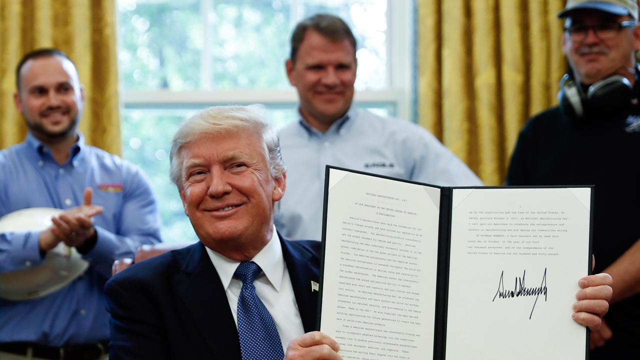 President Trump signs the National Manufacturing Day proclamation in the Oval Office. 