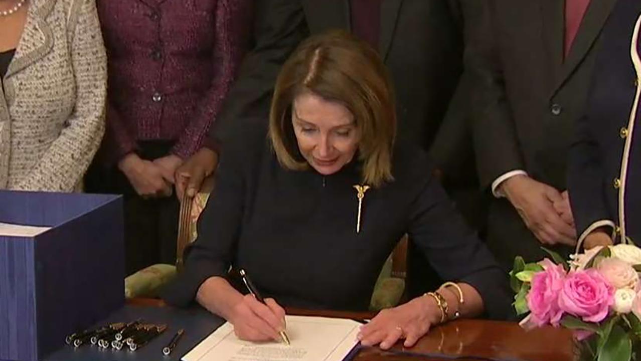 House Speaker Nancy Pelosi (D) signs the bipartisan border security spending bill.