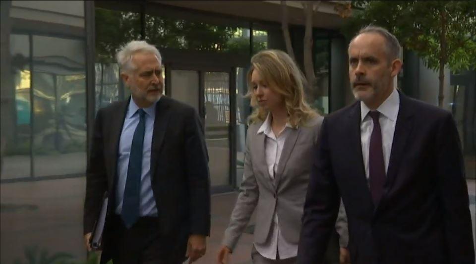 Former Theranos President Sunny Balwani enters a federal court building in San Jose, California accompanied by his legal team, followed by its former CEO Elizabeth Holmes. 