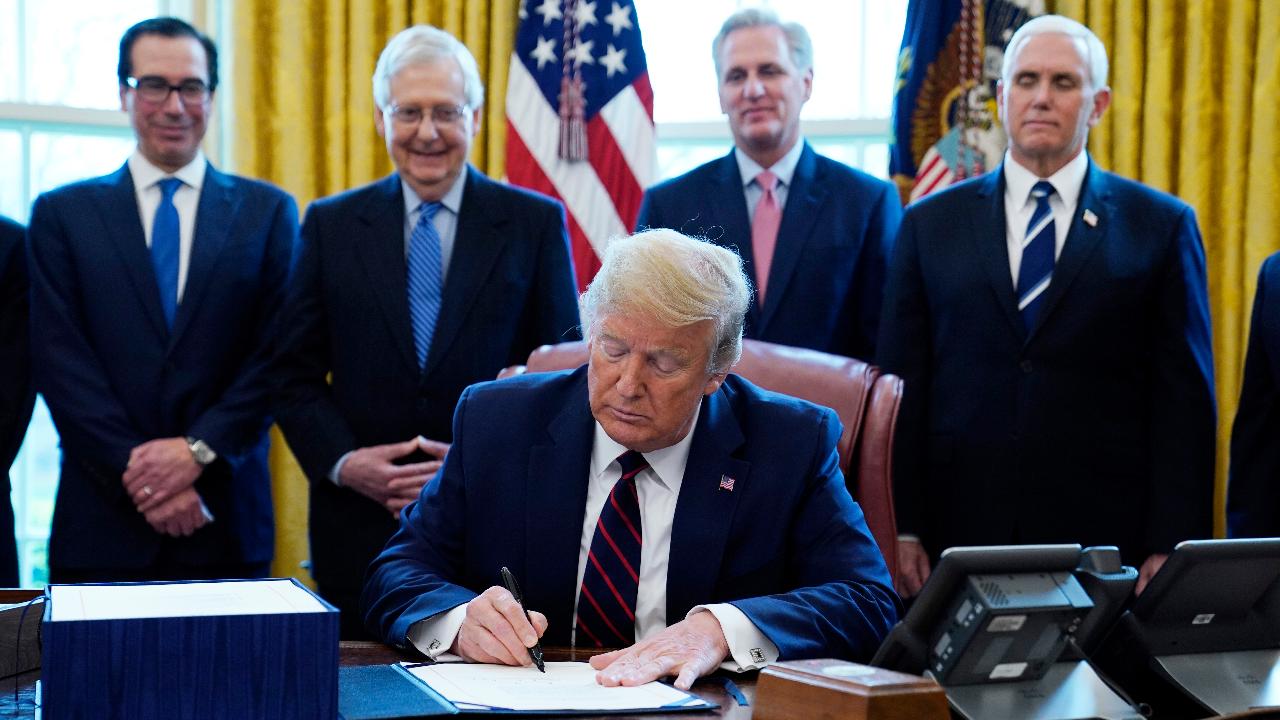 President Trump officially signs the $2 trillion coronavirus relief bill in the Oval Office. 